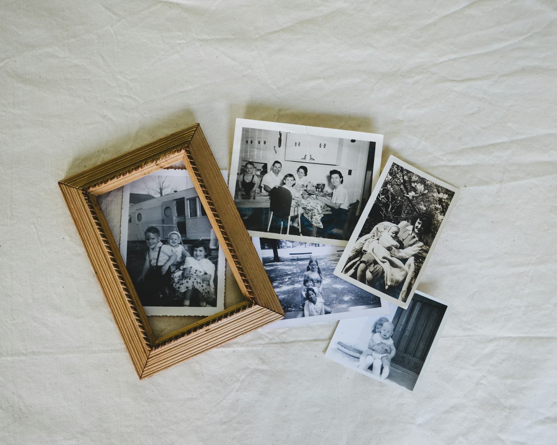Elderly hands gently holding vintage family photographs, representing cherished memories being preserved